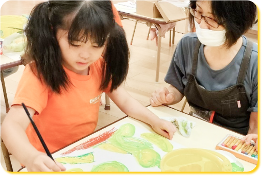 アクティビティの絵画で絵を描く園児