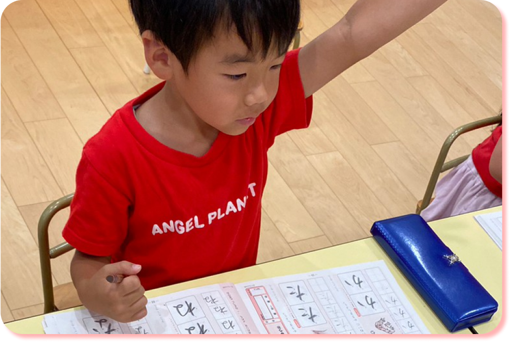 書き方のアクティビティで、手を挙げる園児