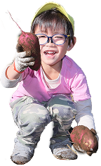 掘ったサツマイモを手に笑顔の園児