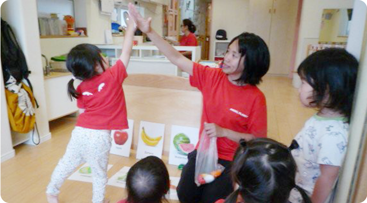 園児とハイタッチする外国人スタッフ