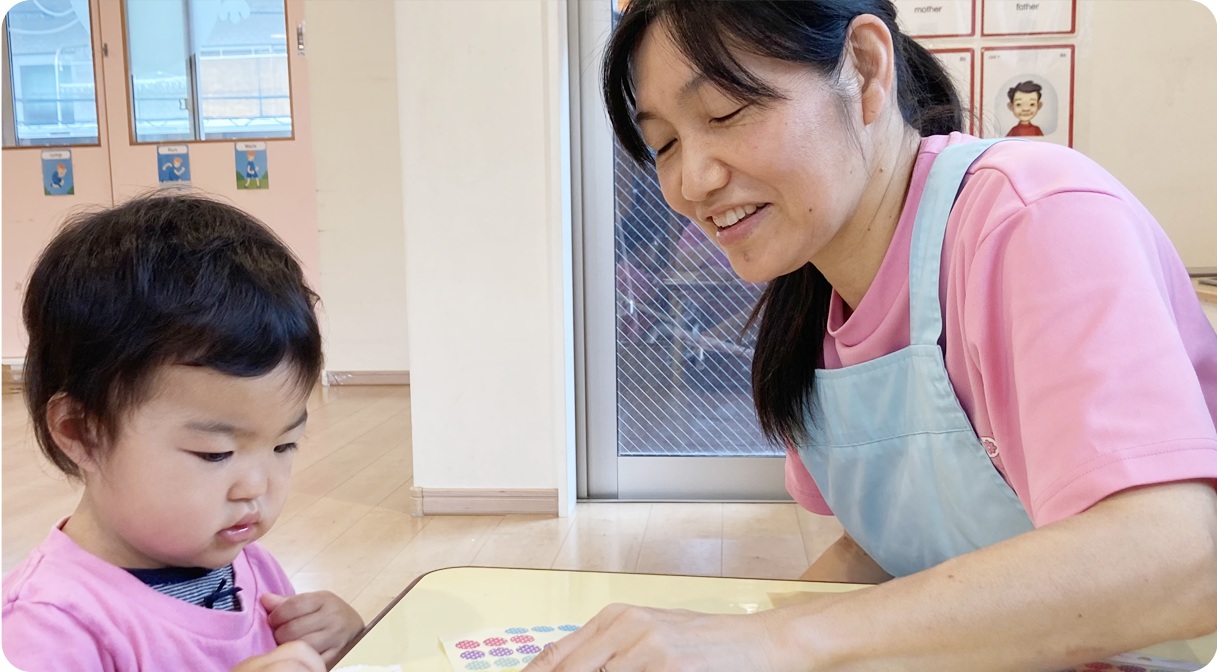 保育士から優しく学びを受ける園児