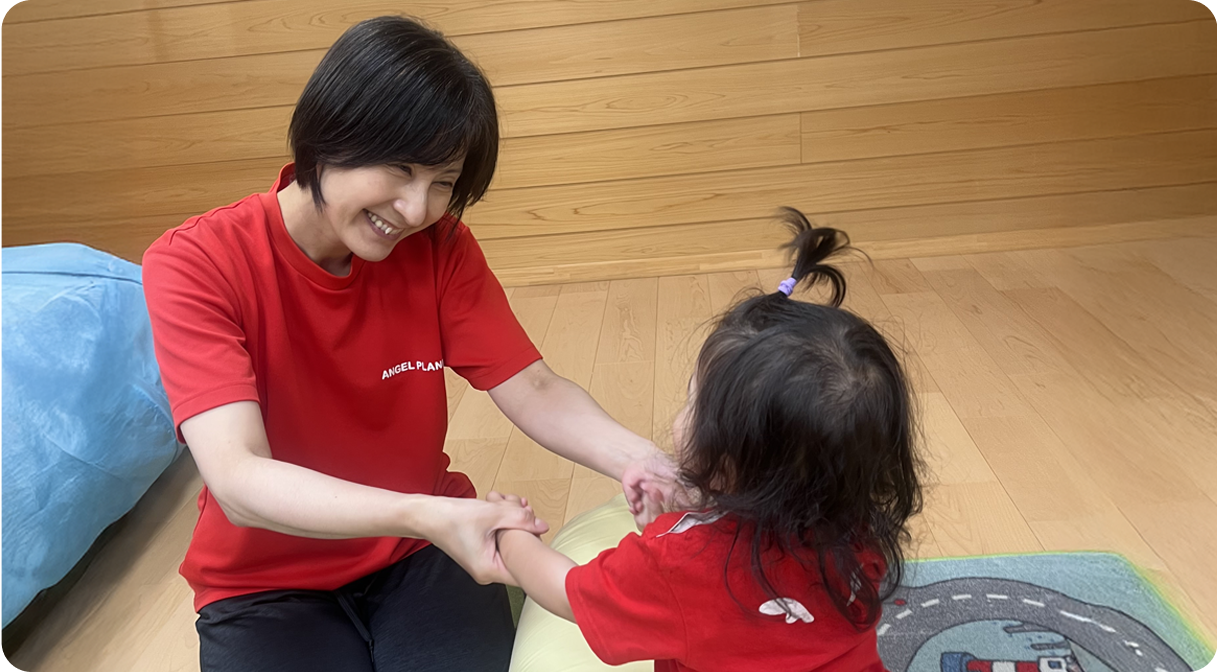 園児たちと手遊びする保育士