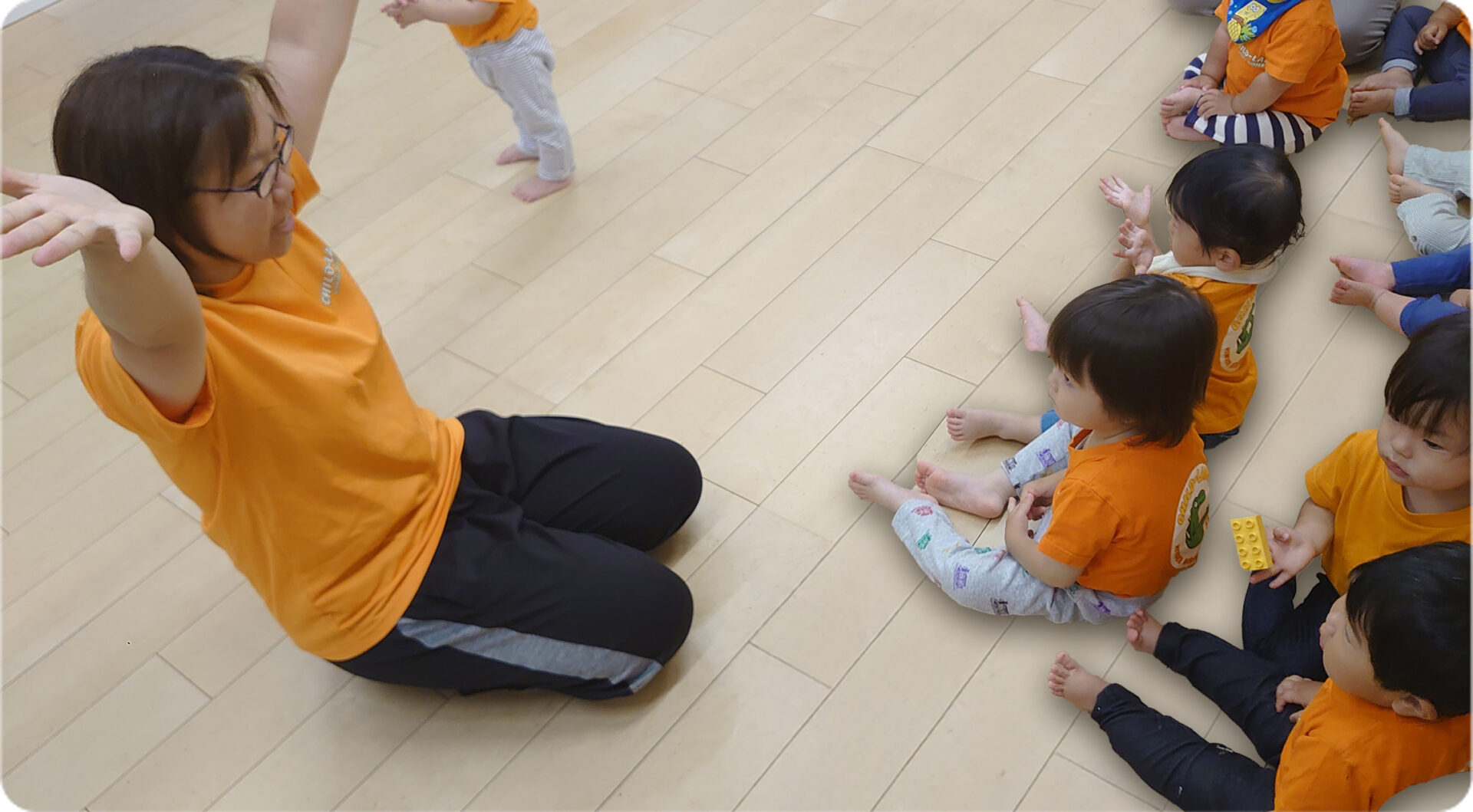 園児たちと手遊びする保育士