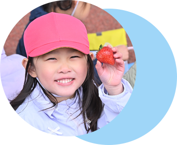 摘み取ったいちごを持って満面の笑みの園児